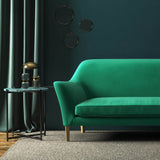 Sofa covered in a green velvet upholstery fabric
