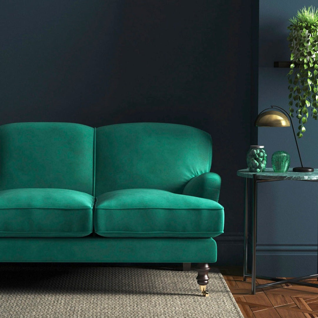 Sofa covered in a green velvet upholstery fabric