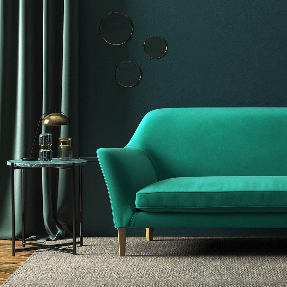 Sofa covered in a green velvet upholstery fabric 
