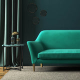 Sofa covered in a green velvet upholstery fabric 