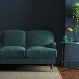 Sofa covered in a blue velvet upholstery fabric