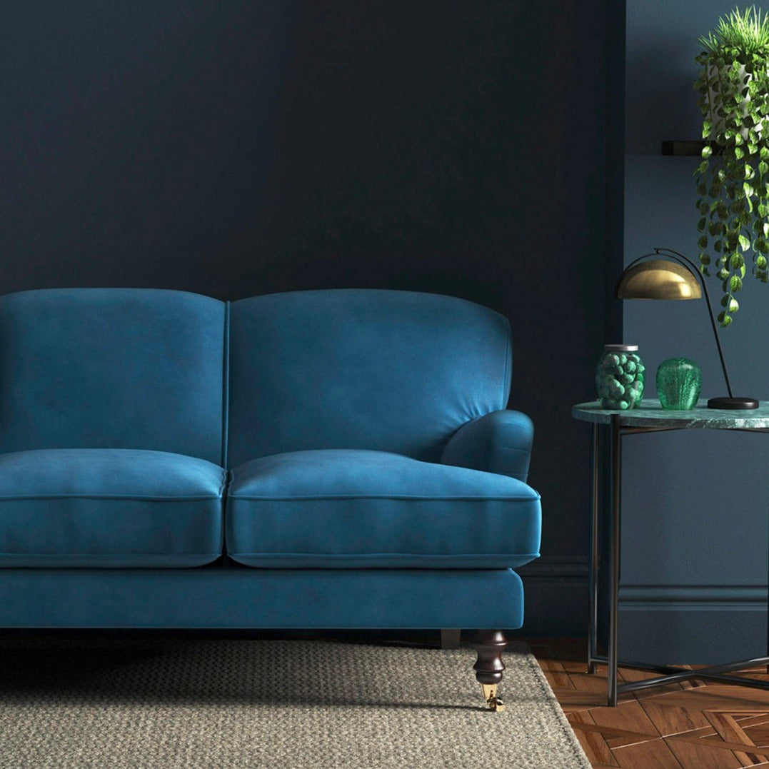 Sofa covered in a blue velvet upholstery fabric