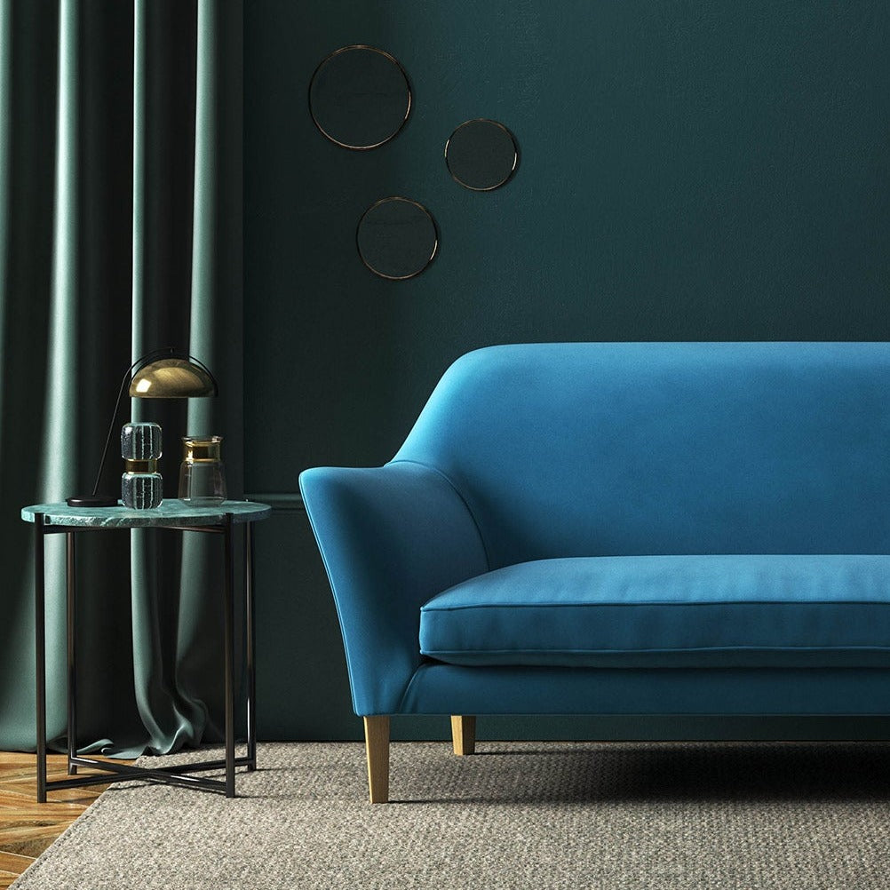 Sofa covered in a blue velvet upholstery fabric 