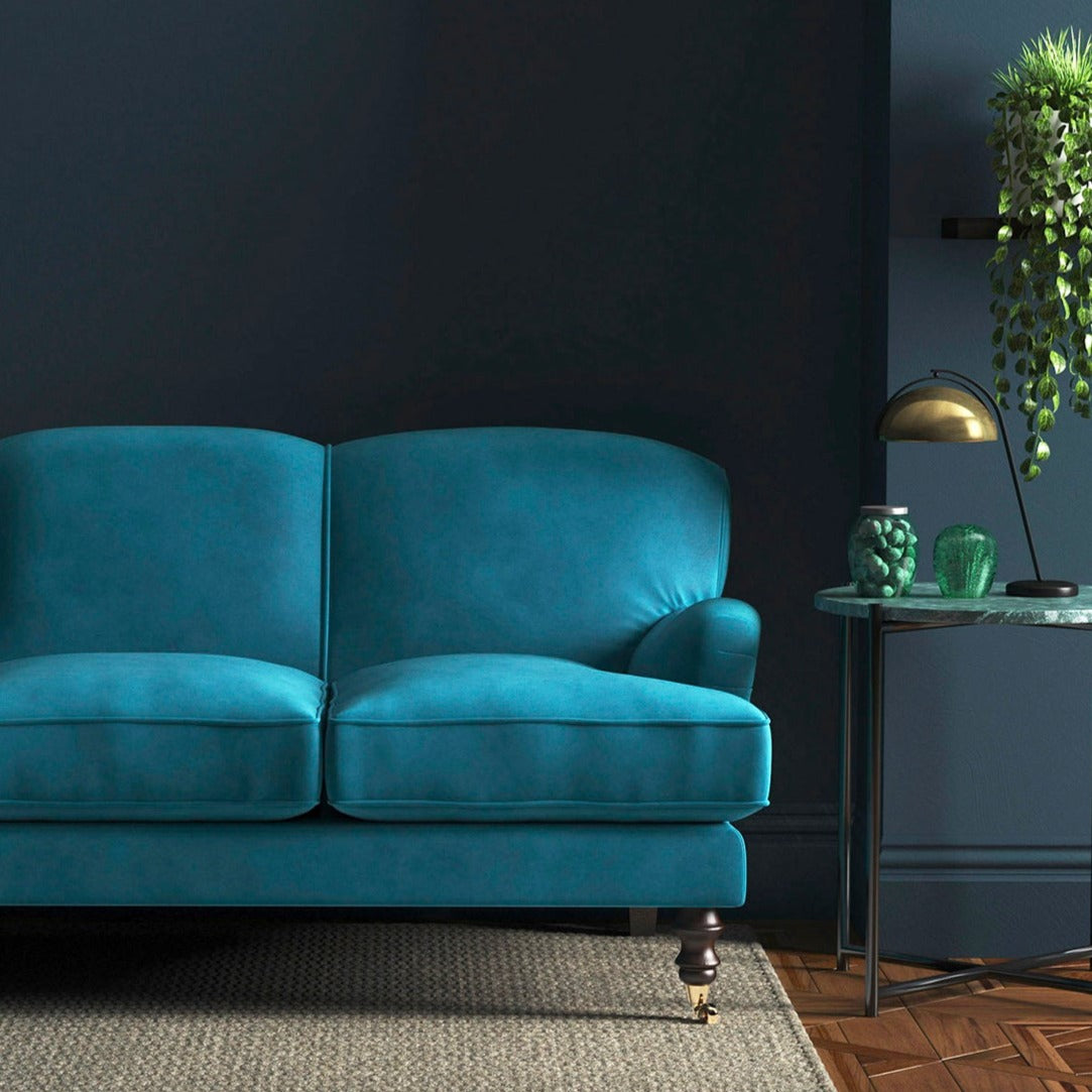 Sofa covered in a blue velvet upholstery fabric