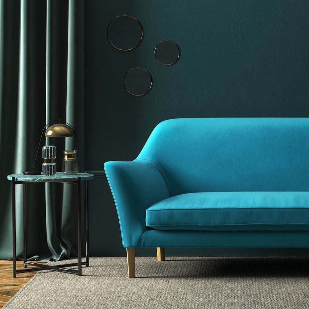 Sofa covered in a blue velvet upholstery fabric 