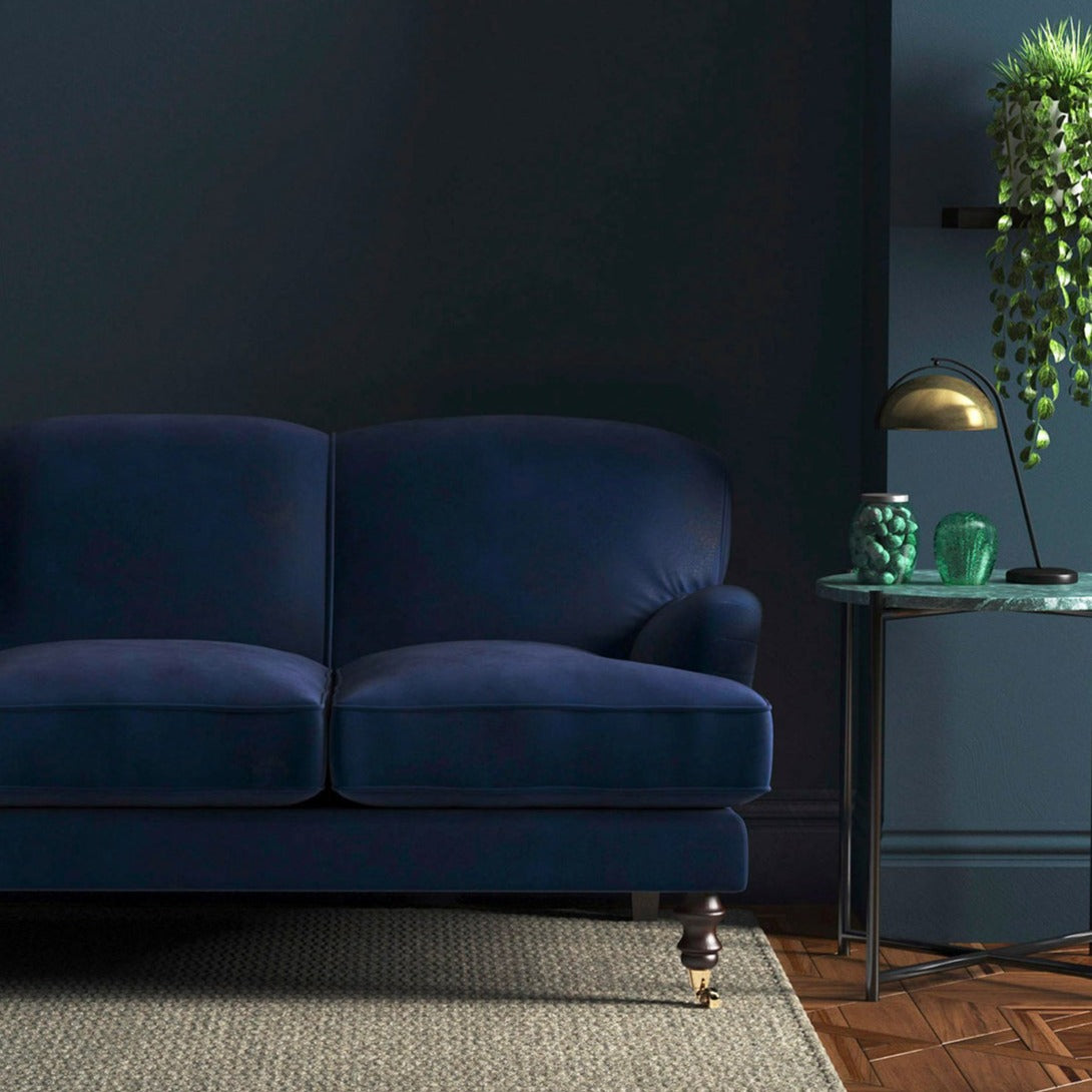 Sofa covered in a blue velvet upholstery fabric