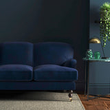 Sofa covered in a blue velvet upholstery fabric