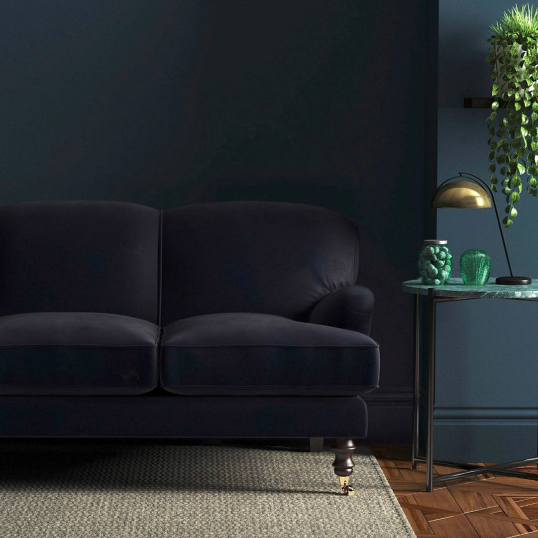 Sofa covered in a blue velvet upholstery fabric