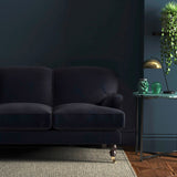 Sofa covered in a blue velvet upholstery fabric