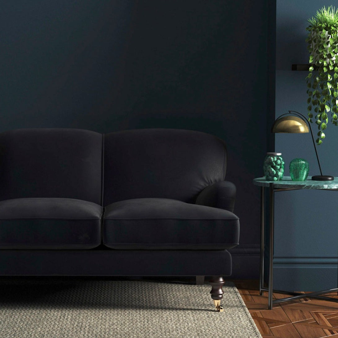 Sofa covered in a navy velvet upholstery fabric