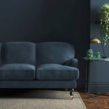 Sofa covered in a blue velvet upholstery fabric