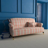 Sofa upholstered in light red and neutral wool check fabric with large white woven damask print.