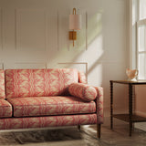 Sofa upholstered in a red floral fabric with stripe design