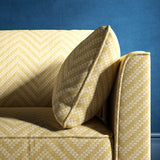 Sofa upholstered in a light yellow and neutral herringbone upholstery fabric