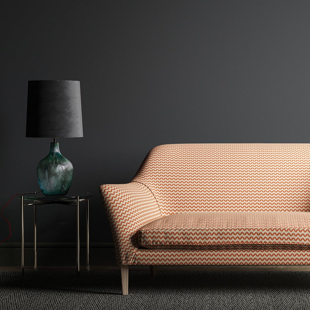 Sofa upholstered in a small scale orange and off white geometric weave