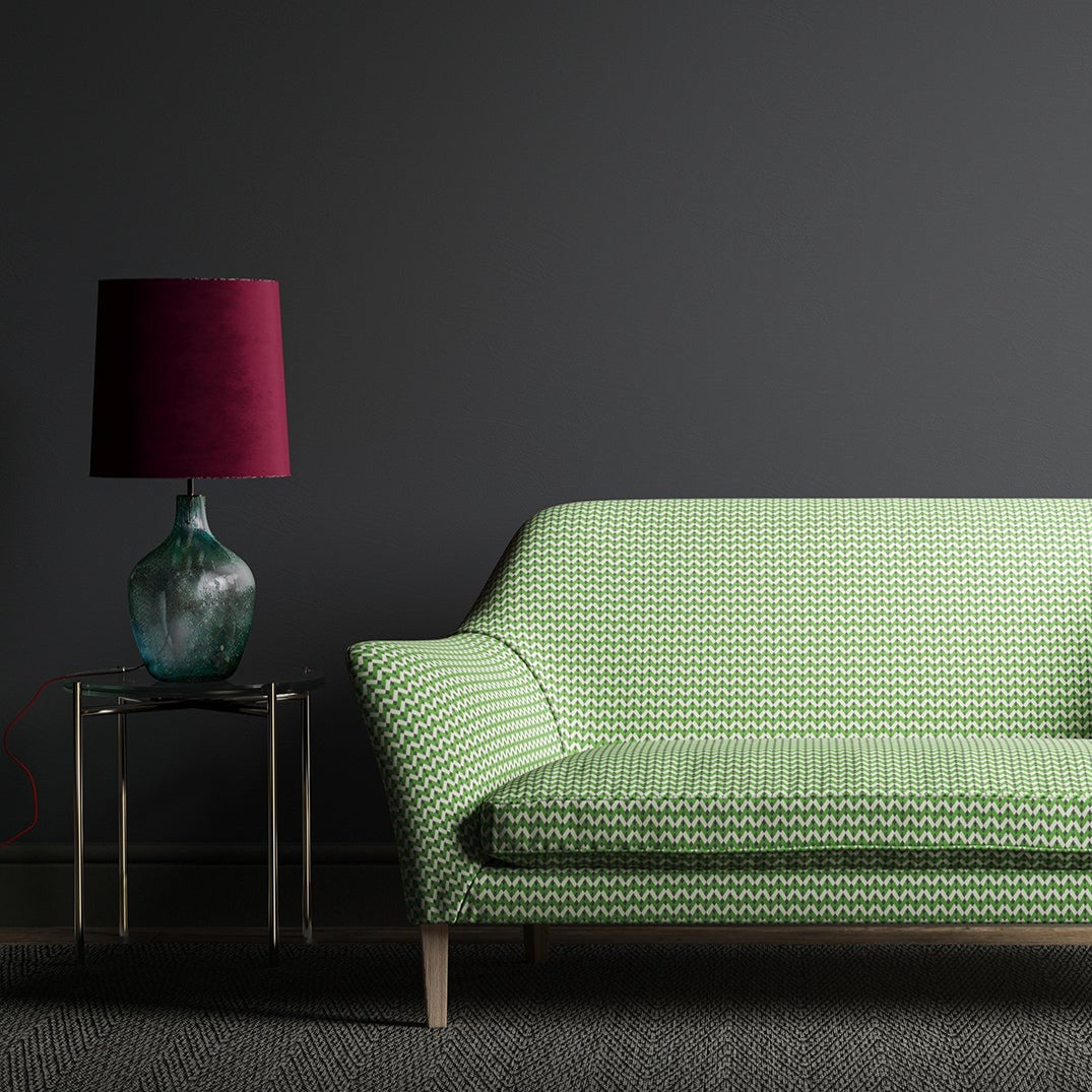 Sofa upholstered in a green, cream and dark grey geometric weave fabric