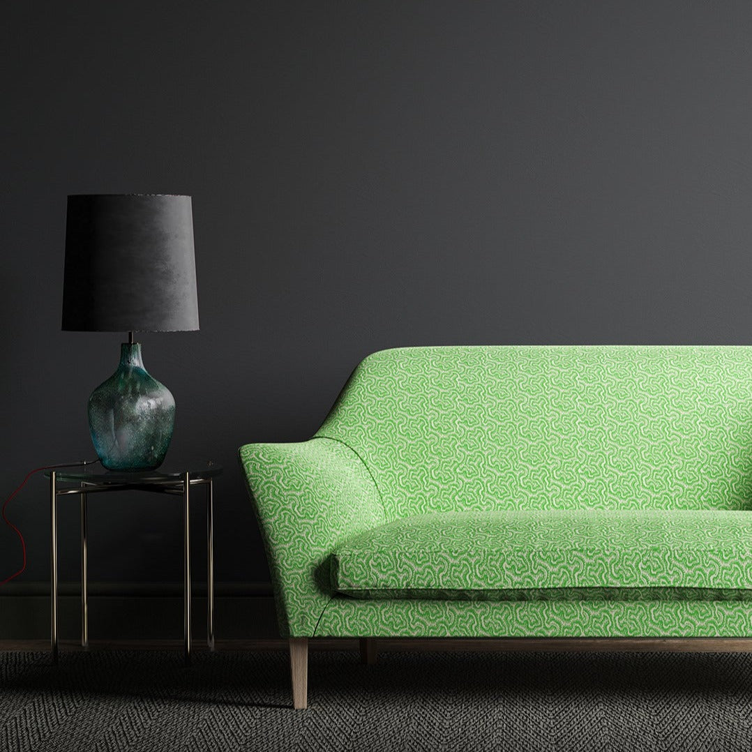 Sofa upholstered in a green and neutral wavy weave fabric.