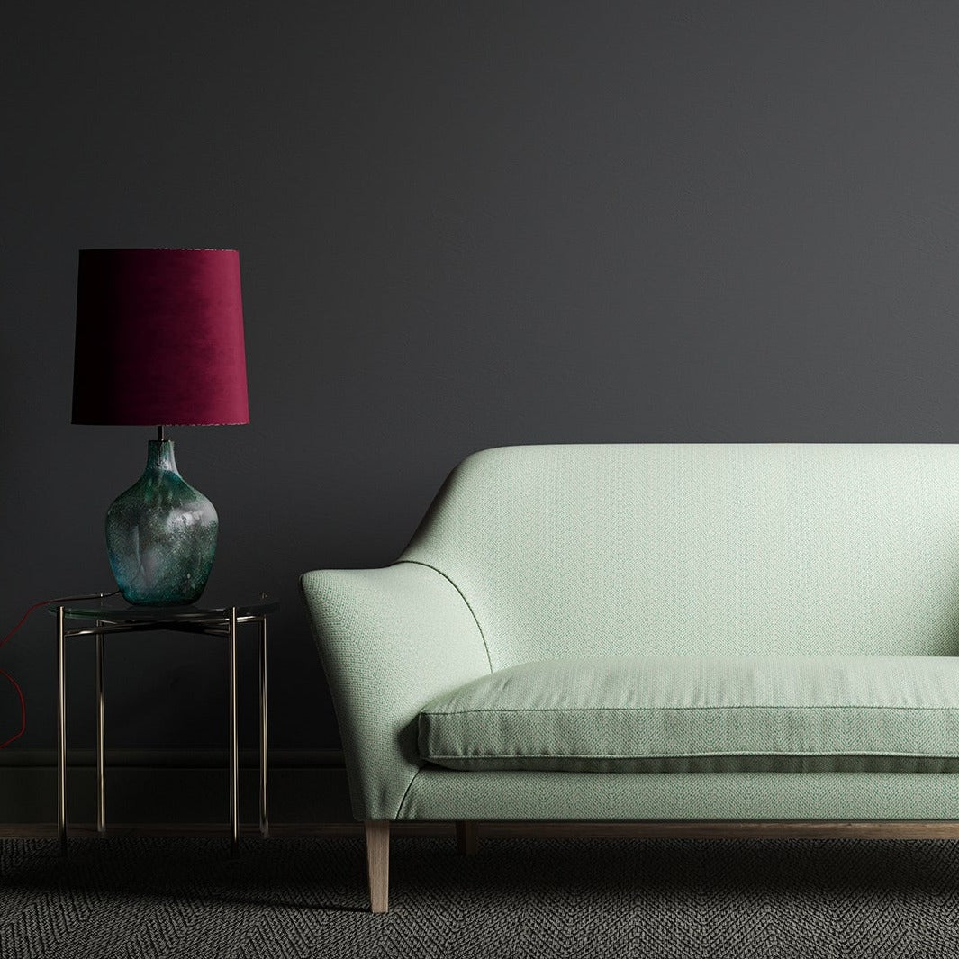 Sofa upholstered in a turquoise and white geometric weave fabric.
