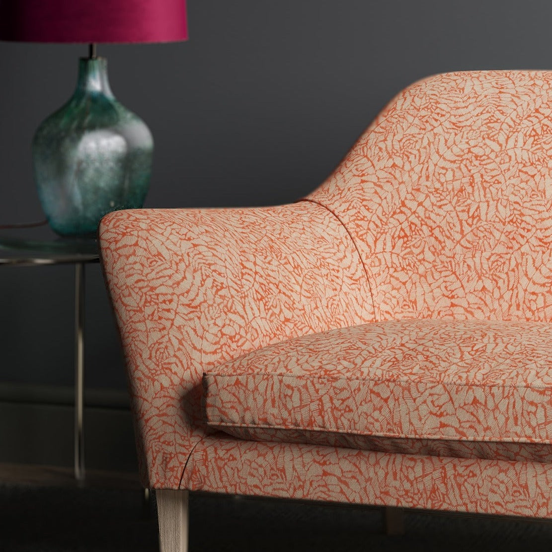 Sofa upholstered in a orange woven fabric with small white print