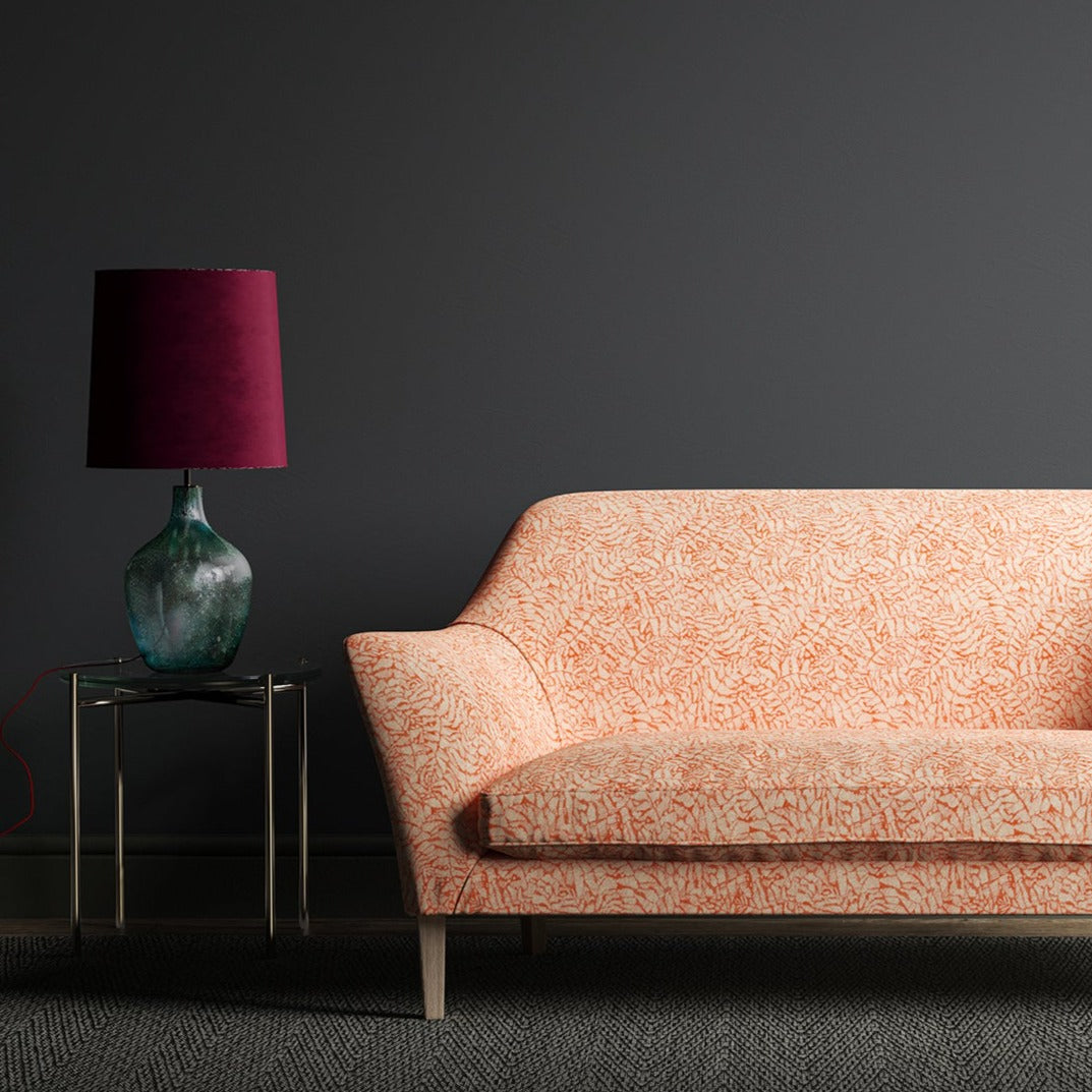 Sofa upholstered in a orange woven fabric with small white print