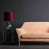 Sofa upholstered in a orange woven fabric with small white print