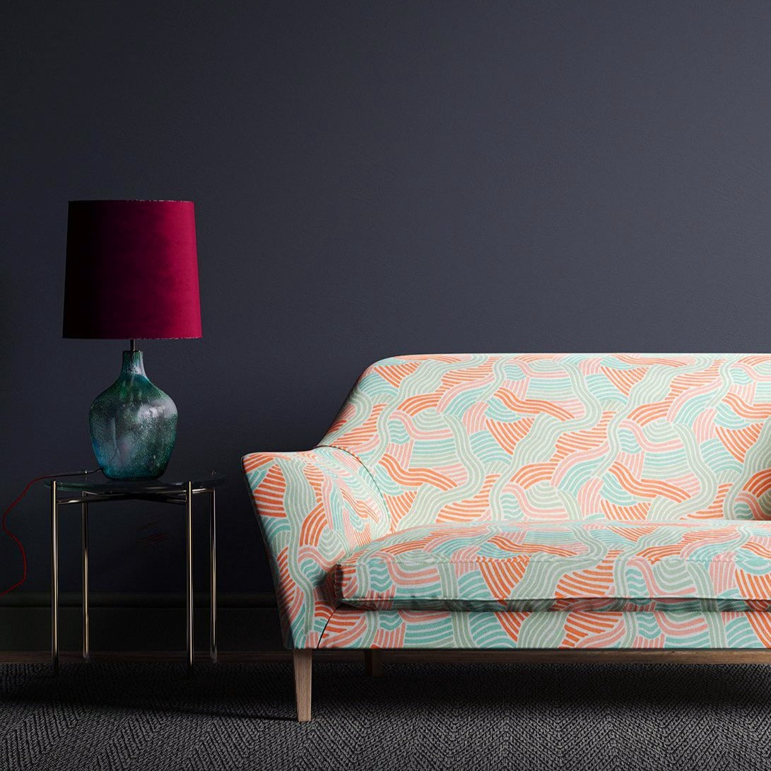 Sofa showcasing a wavy design in pastel pink and green on a linen fabric