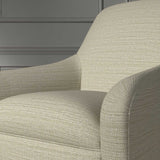Close up of a chair covered in a woven fabric in a herringbone design in Linen