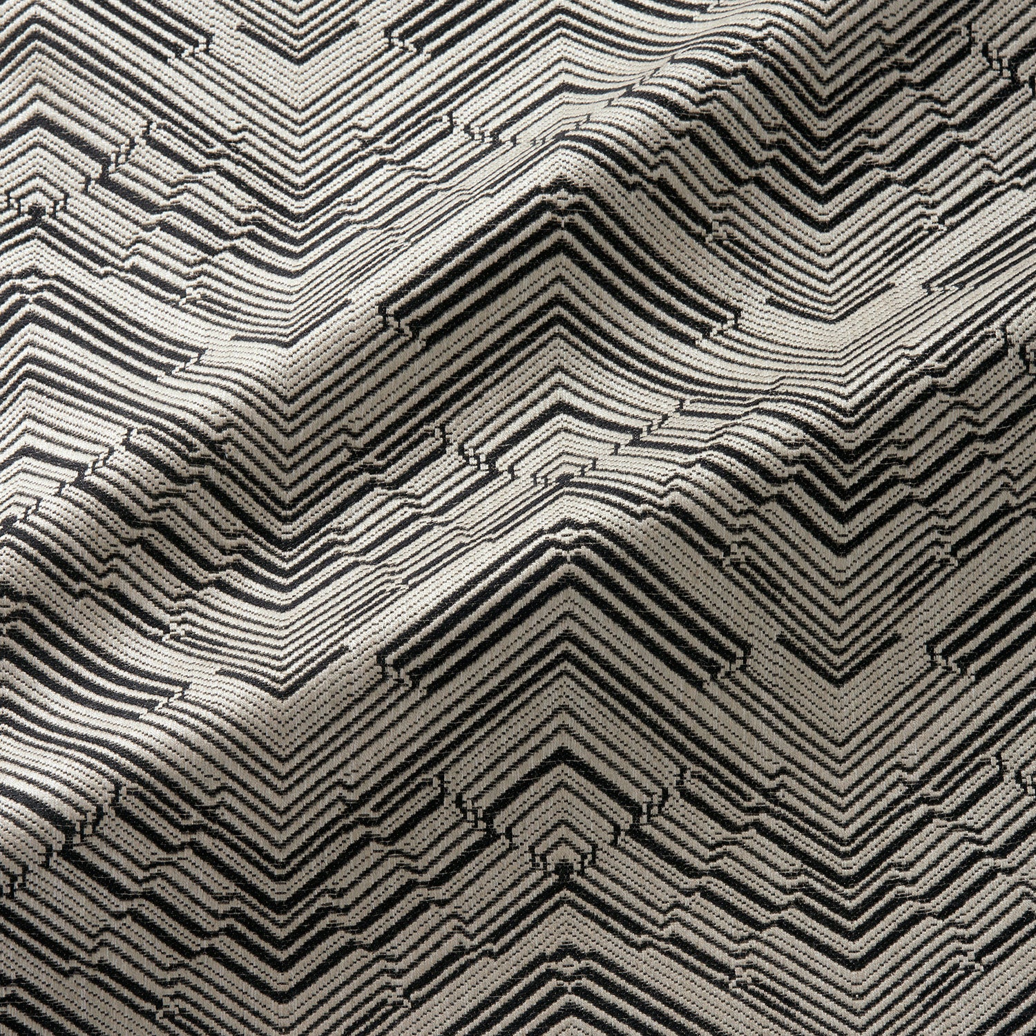 Fabric swatch of a stain resistant herringbone weave design in dark grey colours, suitable for curtains and upholstery