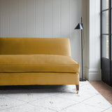 Yellow velvet upholstery fabric on a classic sofa.