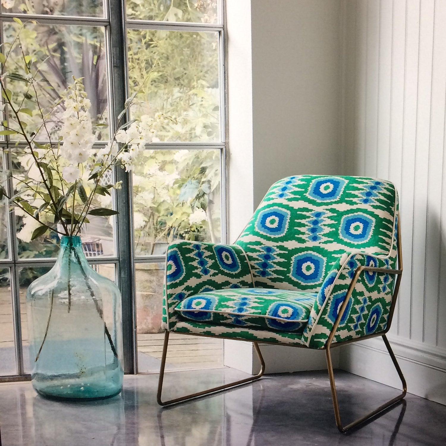 Armchair covered in a printed velvet upholstery fabric featuring a fun, jazzy pattern in Seagreen. 