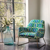 Armchair covered in a printed velvet upholstery fabric featuring a fun, jazzy pattern in Seagreen. 