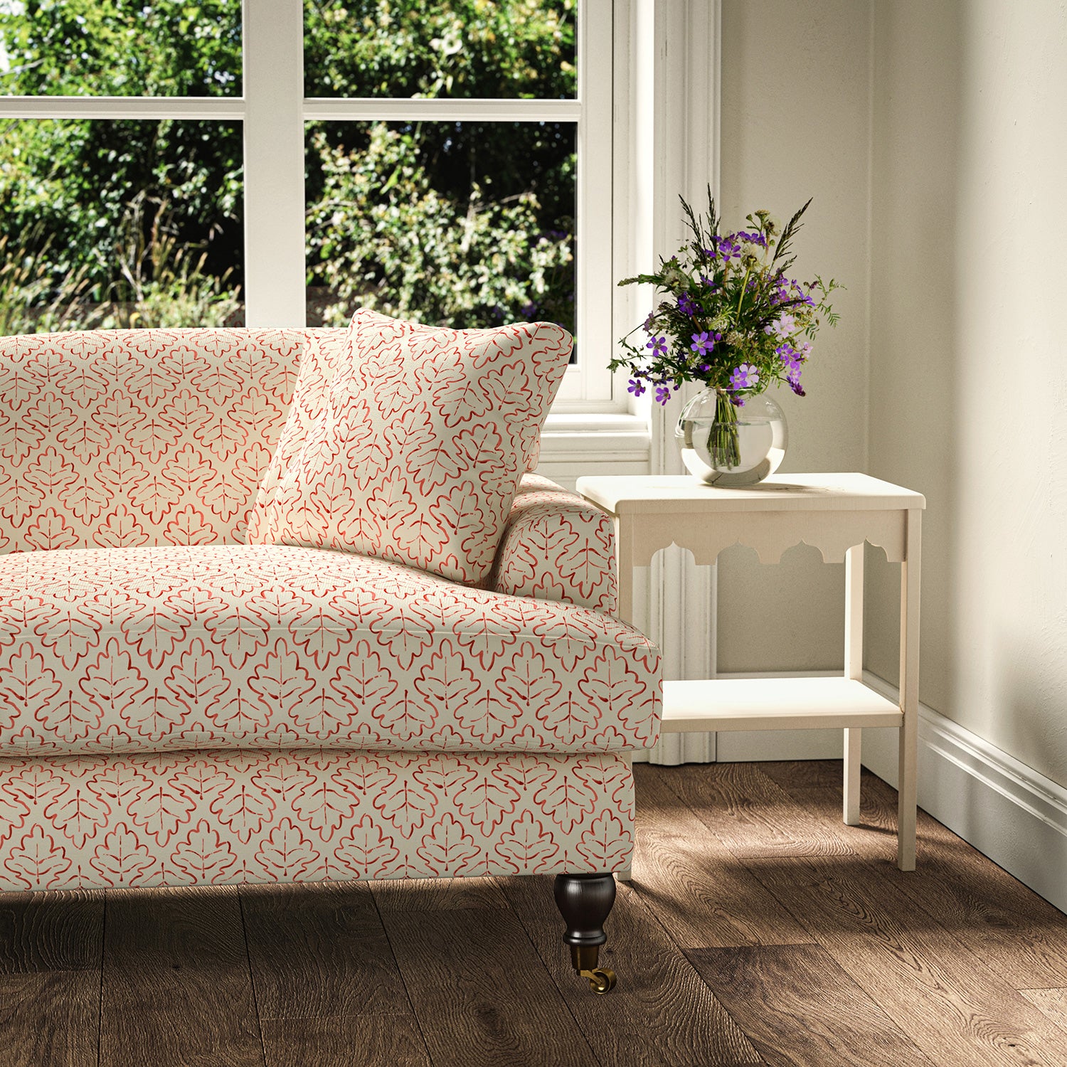 Printed linen fabric – a hand drawn; mirrored leaf motif pattern in red and cream – on a sofa
