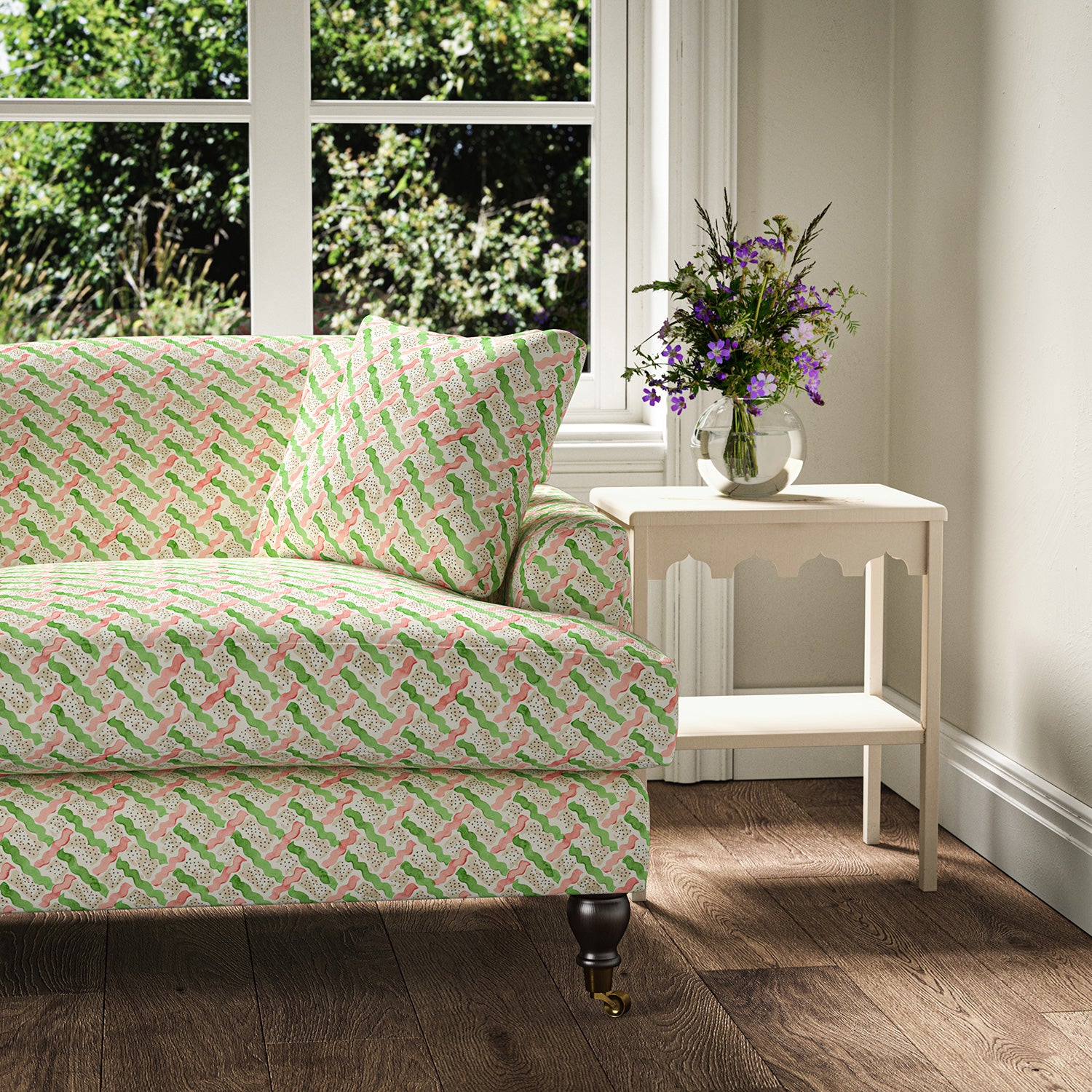 Printed linen fabric - a contemporary lattice design in green, pink, cream and white – on a sofa