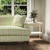 Printed linen fabric - a contemporary lattice design in green, pink, cream and white – on a sofa