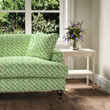 Printed linen fabric - a contemporary lattice design in green, cream and white – on a sofa