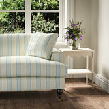 Printed linen fabric – a bold blocks of colour in this inviting stripe are softened with a painterly finish in blue, cream and white – on a sofa