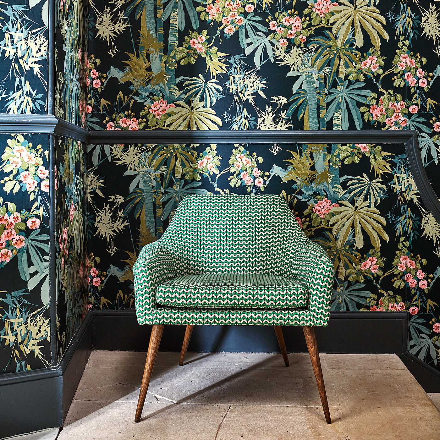 Sitting room with a tropical wallpaper in navy with exotic, floral blossoms intertwined with bamboo.