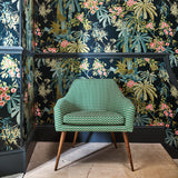 Sitting room with a tropical wallpaper in navy with exotic, floral blossoms intertwined with bamboo.
