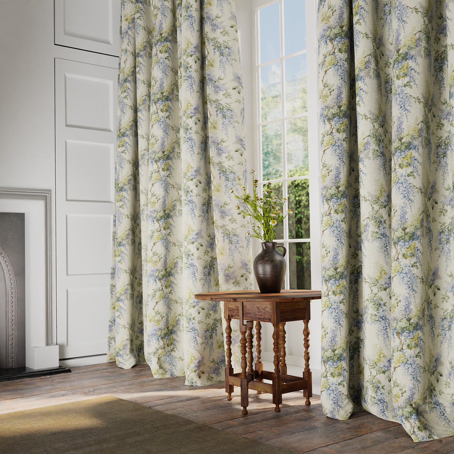 Curtains in a printed linen fabric with a wisteria floral pattern in yellow, green and blue colours.