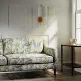 Sofa in a printed linen fabric with a wisteria floral pattern in yellow, green and blue colours.