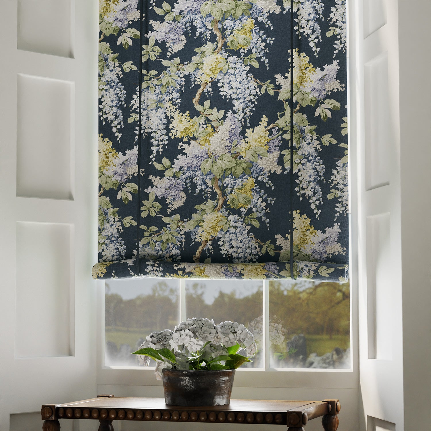 Blinds in a printed linen fabric with a wisteria floral pattern in blue and green colours.
