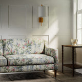Sofa in a printed linen fabric with a wisteria floral pattern in light colours.