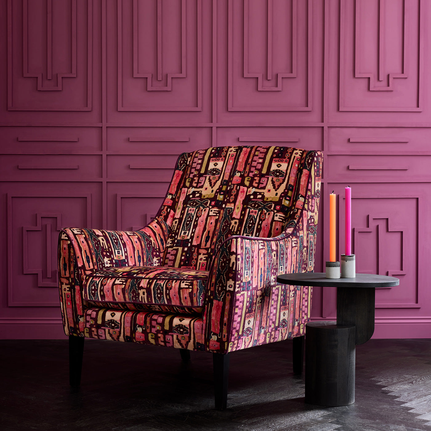 Armchair in a printed velvet fabric with city buildings in pink colours.
