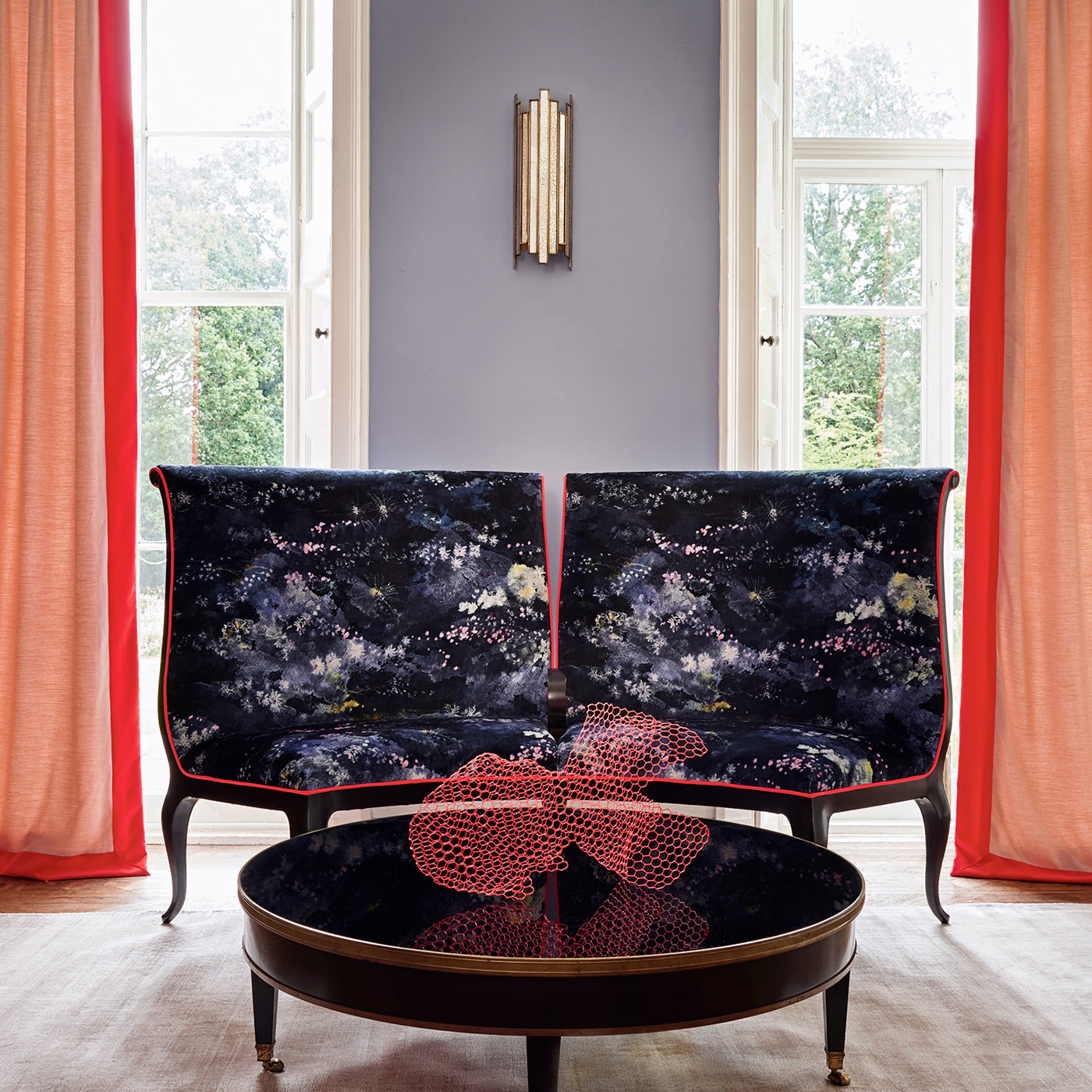 Armchairs in printed velvet fabric with painterly-style skyscape design in blue colours.