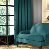 Living room featuring a sofa and curtains in a plain teal eco-friendly fabric
