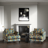 Armchairs in a printed velvet fabric with city buildings in blue and yellow colours.