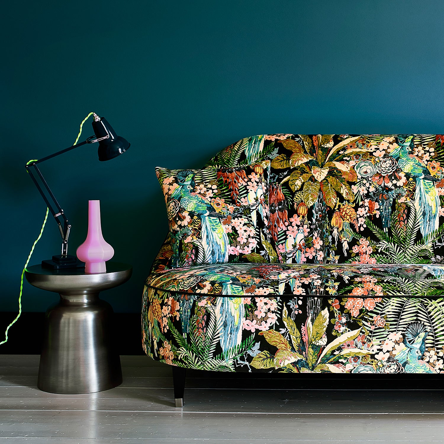 Sofa covered in a printed velvet fabric showcasing a tropical design
