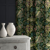 A printed velvet fabric showcasing an archival document, circa 1700s, this stylised floral is lavish, graceful, and timeless in green, shown as curtains