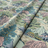 Sample of a printed velvet fabric showcasing a beautiful landscape of mountains, willows, and Oriental-style buildings in blue, pink and green