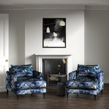 Armchairs in printed velvet fabric with painterly-style skyscape design in blue colours.